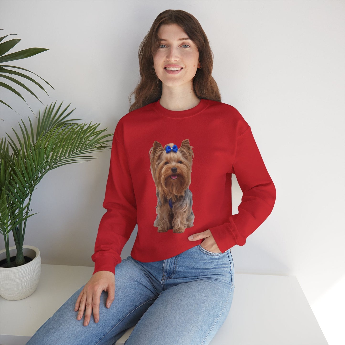 Ragazza seduta che indossa Felpa Girocollo Unisex AKYCO con ritratto di Aky sul davanti e vestibilità comoda, ideale per amanti degli Yorkshire Terrier