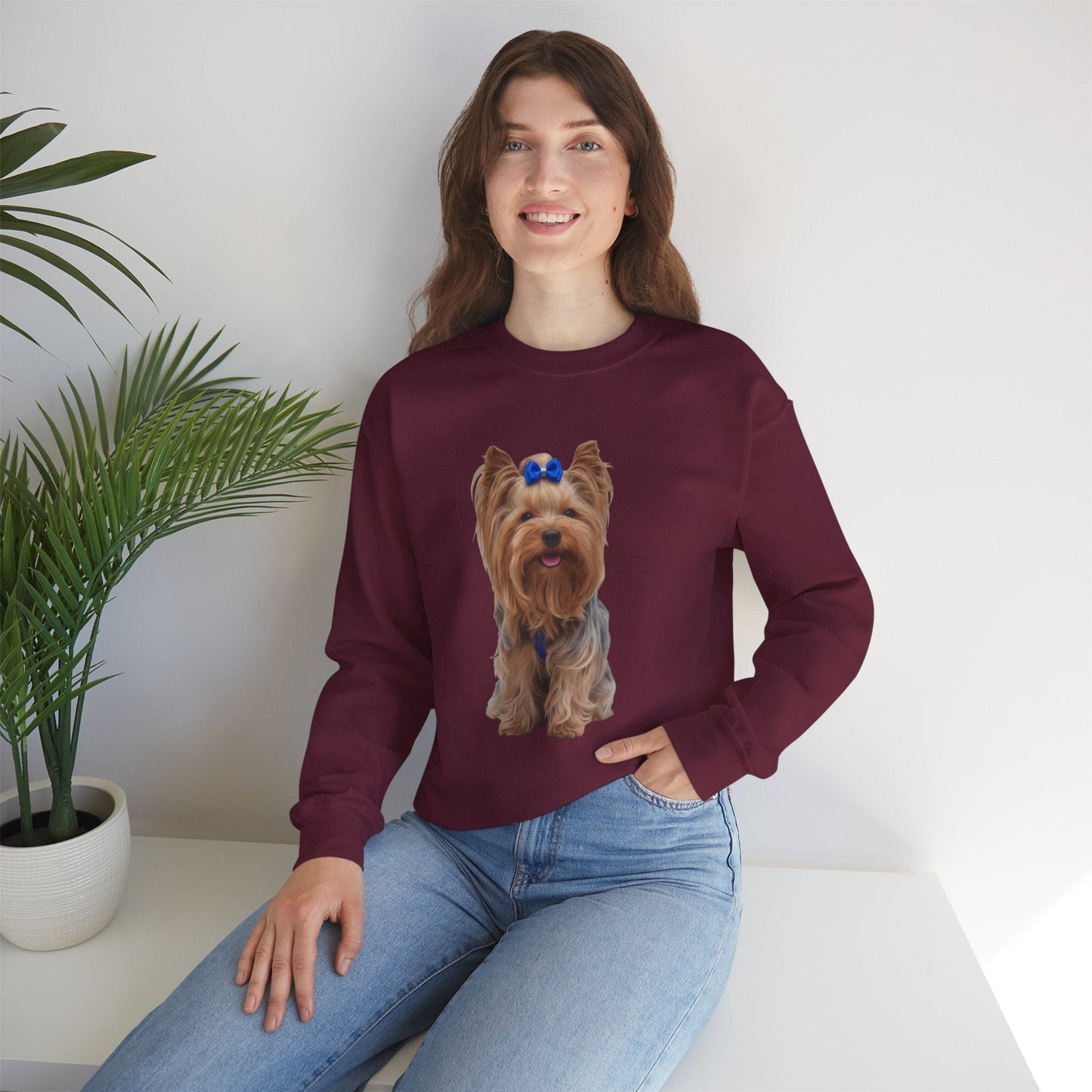 Ragazza seduta che indossa Felpa Girocollo Unisex AKYCO con ritratto di Aky sul davanti e vestibilità comoda, ideale per amanti degli Yorkshire Terrier