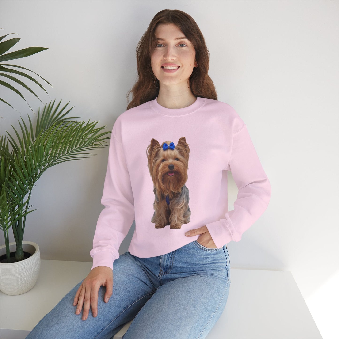 Ragazza seduta che indossa Felpa Girocollo Unisex AKYCO con ritratto di Aky sul davanti e vestibilità comoda, ideale per amanti degli Yorkshire Terrier