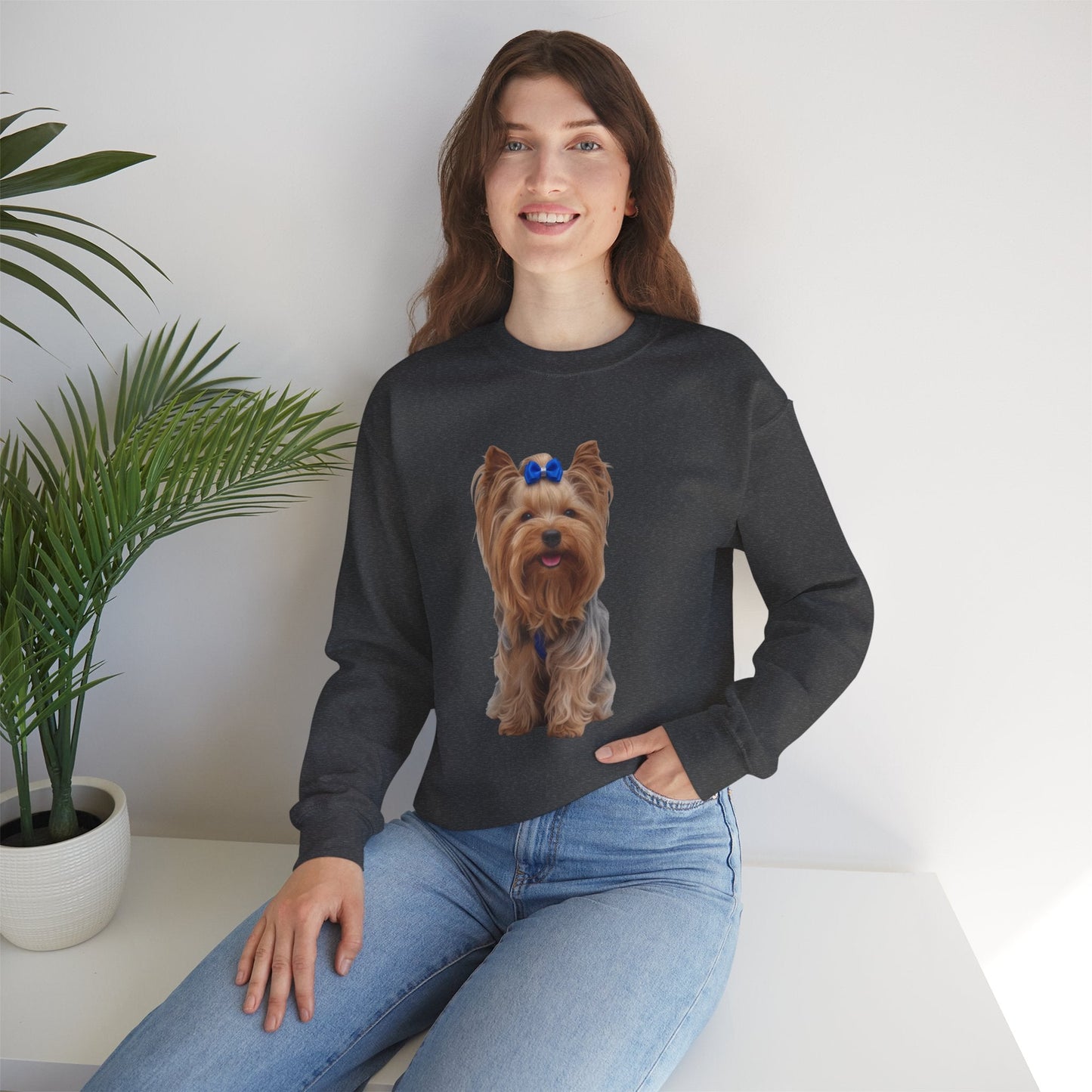 Ragazza seduta che indossa Felpa Girocollo Unisex AKYCO con ritratto di Aky sul davanti e vestibilità comoda, ideale per amanti degli Yorkshire Terrier