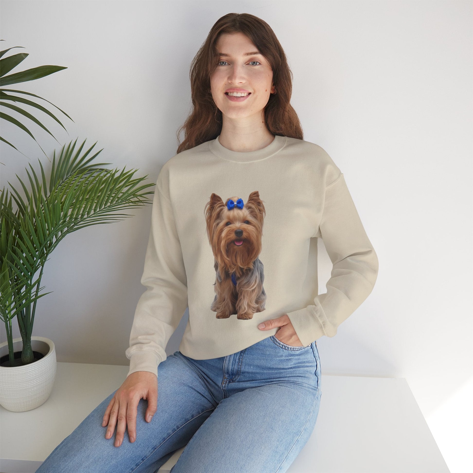 Ragazza seduta che indossa Felpa Girocollo Unisex AKYCO con ritratto di Aky sul davanti e vestibilità comoda, ideale per amanti degli Yorkshire Terrier