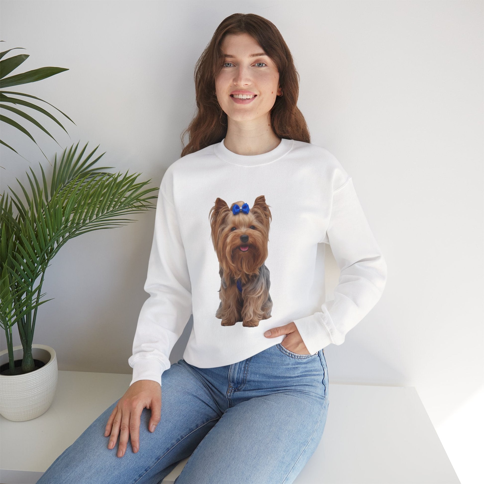 Ragazza seduta che indossa Felpa Girocollo Unisex AKYCO con ritratto di Aky sul davanti e vestibilità comoda, ideale per amanti degli Yorkshire Terrier